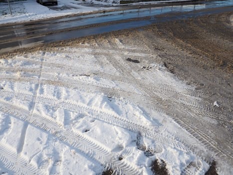 A fork or siding from a roundabout. Snowdrifts on the side of the road. Bad weather and traffic. Snow on asphalt. Difficult driving conditions. Winter slosh on the road. Braking distance of a car.