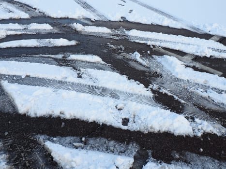 A fork or siding from a roundabout. Snowdrifts on the side of the road. Bad weather and traffic. Snow on asphalt. Difficult driving conditions. Winter slosh on the road. Braking distance of a car.