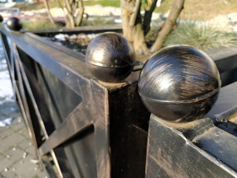Ball made of cast iron or steel. Decorations for decoration of the streets and squares of the city for the holiday of Christmas. Metal balls. Detail of an outdoor container pot for flowers or shrubs