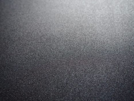 Black glitter texture christmas background. Bent shiny velvet paper.