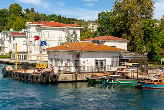 Kanlica Iskelesi, or Kanlica Ferry Terminal with background of dense green trees, white wooden buildings, and clear, in a sunny summer day, located in Asian side of Bosphorus Strait, Istanbul, Turkey