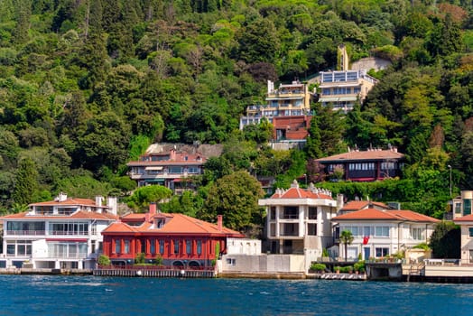 View from Bosphorus strait of the green mountains of the Asian side, with traditional houses and dense trees in a summer day, Istanbul, Turkey