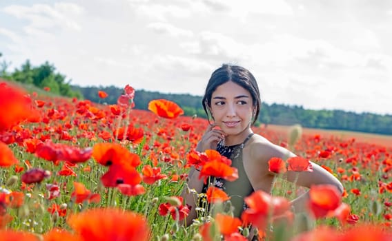pretty young woman enjoying sun in poppy field