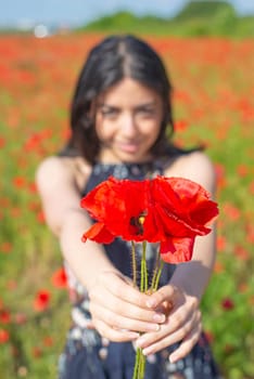happy young woman with bouquet in poppy field
