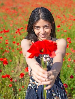 happy young woman with bouquet in poppy field