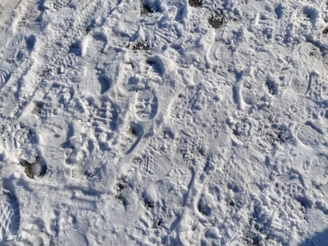 Footprints of boots in the snow. Lots of human footprints on fresh white crust