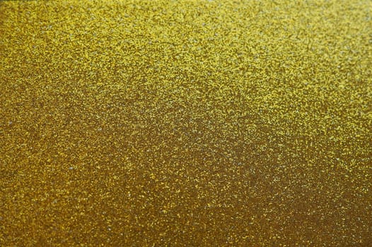Gold close up. Golden glitter texture background. Sparkling glitter wrapping paper with sequins and sparkles. Festive golden bokeh and glitter. Beautiful background. Bokeh light of gold glitters.