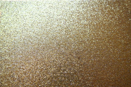 Gold close up. Golden glitter texture background. Sparkling glitter wrapping paper with sequins and sparkles. Festive golden bokeh and glitter. Beautiful background. Bokeh light of gold glitters.