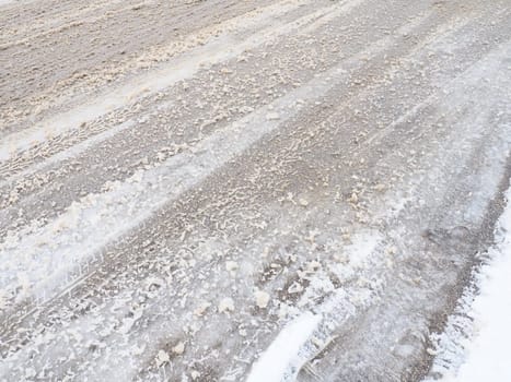 Snowdrifts on the side of the road. Bad weather and traffic. Snow on asphalt. Difficult driving conditions. Winter slosh on the road. Braking distance of a car