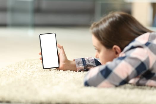 Teen using phone showing blank screen on the floor at home