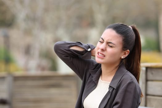 Teen complaining in a park suffering neck ache