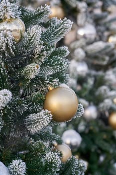 Christmas tree with Christmas tree decorations and snow in a garden
