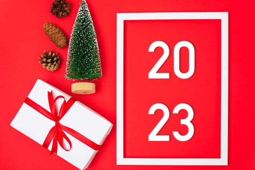 Happy New Year 2023 background. Banner Christmas gifts and decorations with 2023 years number on red background, Flat lay, top view, copy space