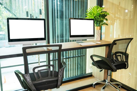 Workspace desk. Computer desktop blank screen in front of window in office, blank screen monitor on modern working desk, interior modern equipment on table