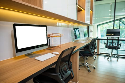 Workspace desk. Computer desktop blank screen in front of window in office, blank screen monitor on modern working desk, interior modern equipment on table