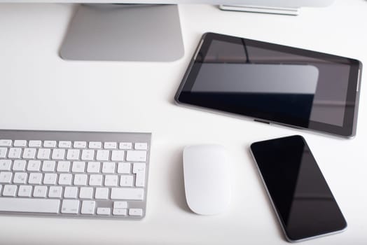 Desktop monitor with a wireless keyboard, mouse, dvd drive, a smartphone and a tablet