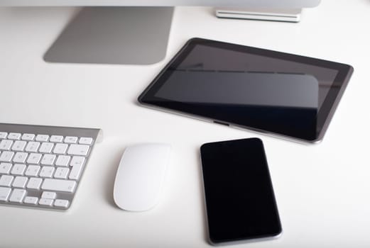 Desktop monitor with a wireless keyboard, mouse, dvd drive, a smartphone and a tablet