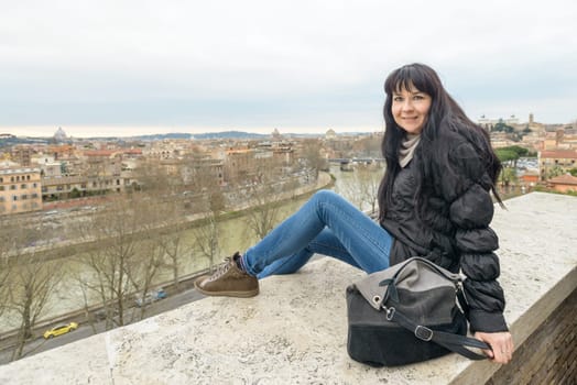 Tourist girl and Landscape of Rome (Italy) from the Oranges Garden. The garden of the Oranges is the name used to describe the park Savelli, a park in Rome of about 7,800 m², located on the Aventine Hill, the Ripa district, which offers an excellent view of the city.