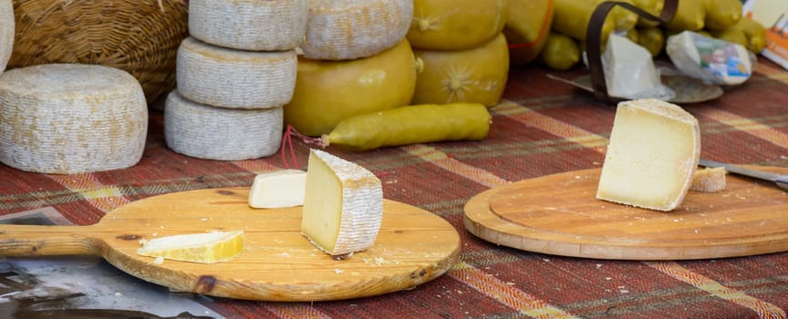 Italian cheeses for sale to the market on a wooden cutting board ready to be tasted