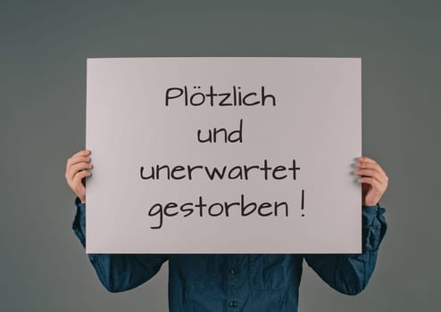 Died suddenly and unexpectedly stands in german language on the sign, clarification of the increase of mortality, death rate covid-19 jab