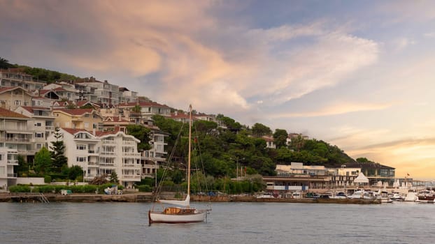 Sailboat with background of the mountains of Kinaliada island from Marmara Sea, with traditional summer houses and boats, and Istanbul, Turkey