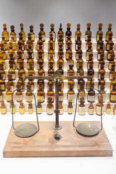 Grasse, France - August 2022: collection of ancient perfumes in laboratory with vintage balance