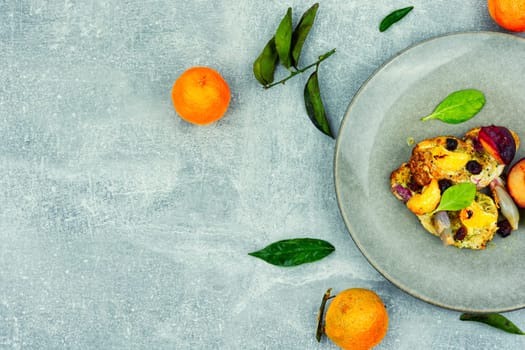 Pork chop cooked with plums and tangerine. Baked meat steak meat in sweet fruits sauce