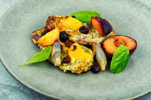 Pork chop cooked with plums and tangerine. Baked meat steak meat in sweet fruits sauce