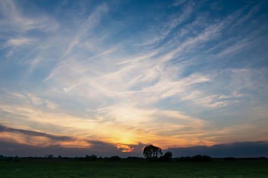 White clouds on blue sky after sunset, photo with low horizon