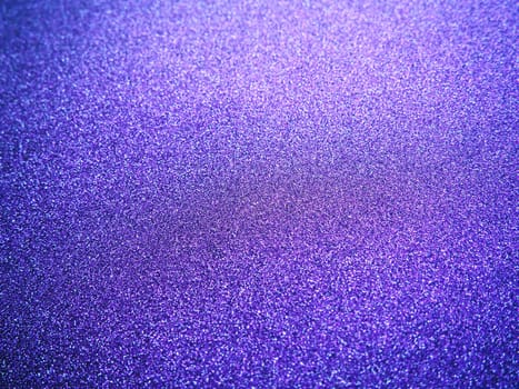 Deep blue. Texture of rough paper or cardboard. Defocused bokeh sparkles and shining. Festive blue background with illuminated sapphire gradient.