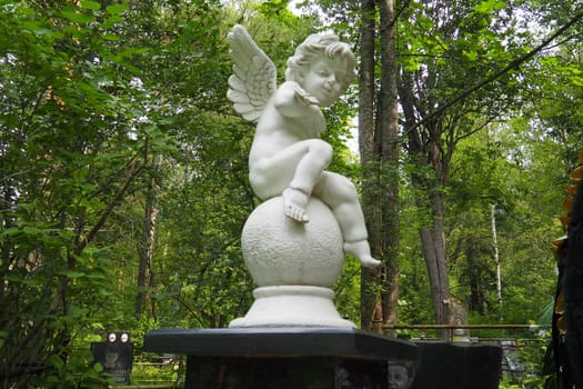Angel in the cemetery monument at the grave of a child sculpture in the form of an angel.
