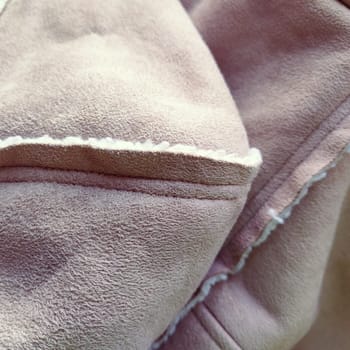 Suede outerwear with a hood. Beige faux suede with sheepskin on the fold of a demi-season garment. seams in the material. Clothing industry and fashion