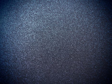 Deep blue shiny bokeh abstract background. Blue - black paper with sparkles. Festive backdrop with dark vignette.