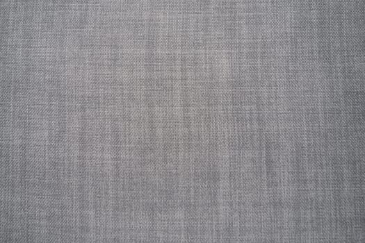 gray background fabric texture. A piece of woolen cloth is neatly laid out on the surface. Weave and textile texture. Dress fabric or for kitchen needs, tablecloth or curtains, close-up. Dash.
