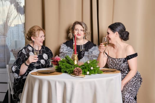 Three joyful middle age women celebrating christmas