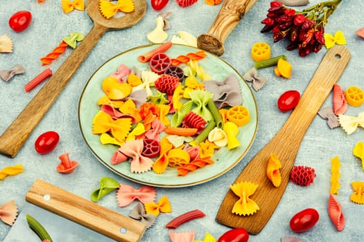 Colorful italian raw pasta on plate. Different types of Italian pasta. Space for text