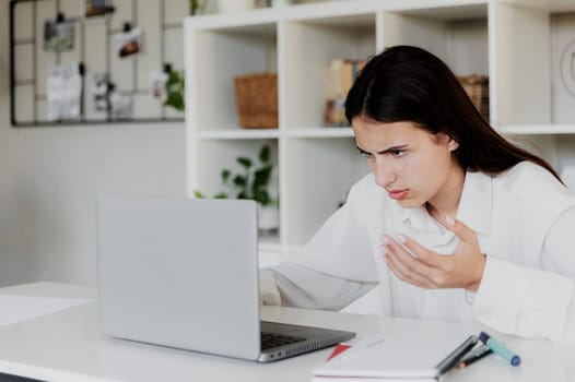Angry young woman at home office desk work online on computer, have problems with device. Unhappy confused female distressed with laptop troubles, looks desperately, credit card issues while shopping