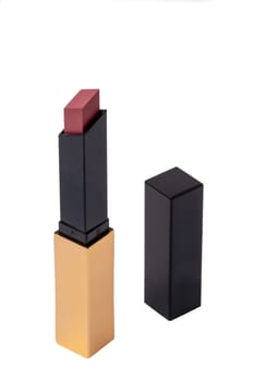 Lipstick isolated. Closeup of a elegant gold yellow lipstick isolated on a white background. Make-up and beauty concept. Macro.