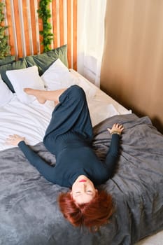 Fifty years old red haired woman rest in bedroom