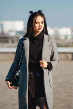 Young woman in warm coat and sweater on the street