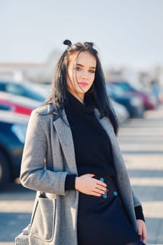 Young woman posing near the parking near the mall