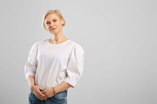 Studio portrait of middle age woman over grey background