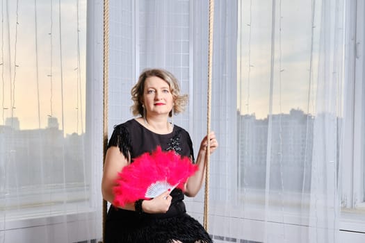 Senior woman swinging on swing at home