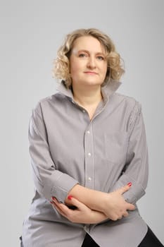 Studio portrait of senior woman in grey shirt with crossed arms
