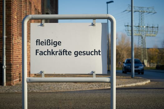 Sign at the entrance of a company premises with the German inscription Fachkrafte gesucht. Translation: Skilled workers wanted