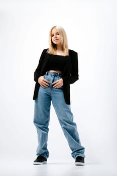 Teenager girl in tank top, jacket and jeans posing