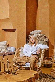 Careless young girl rest in wicker armchair in Middle Eastern style room