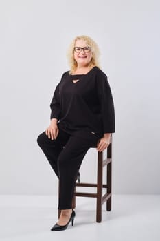 Happy middle age woman in black outfit, studio shot