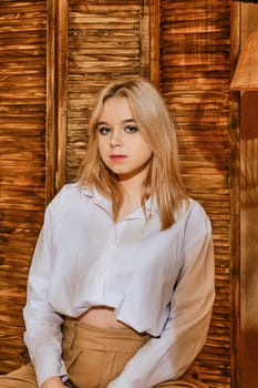 Teenager girl sit on a padded stool in relaxing environment.