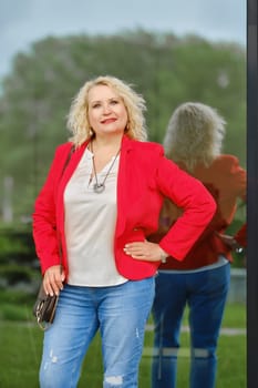 Real estate female agent stands near the reinforced glass wall of the building